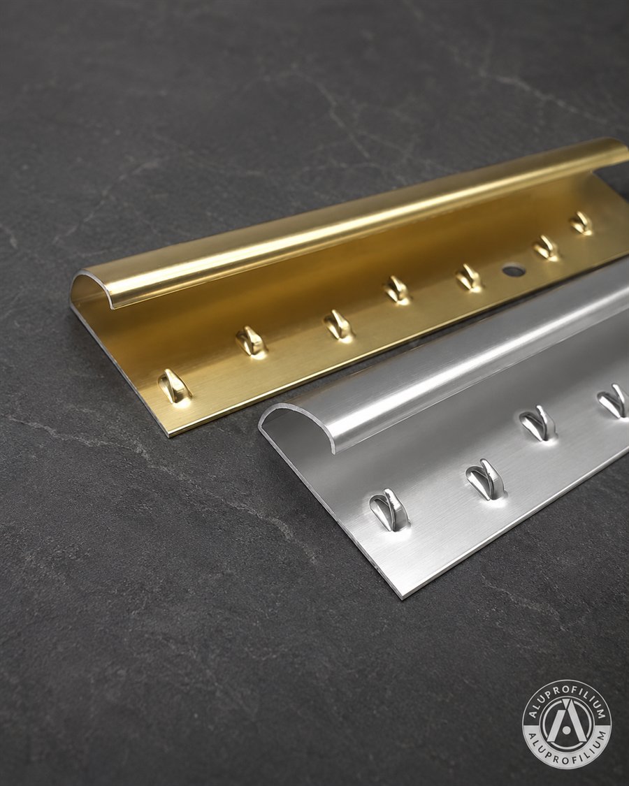 Gold and silver carpet trim aluminum profiles on anthracite tile background