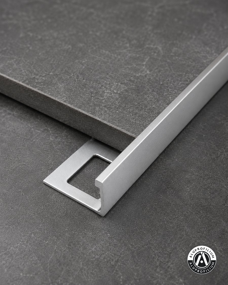 Silver straight edge aluminum tile trim profile on dark ceramic surface